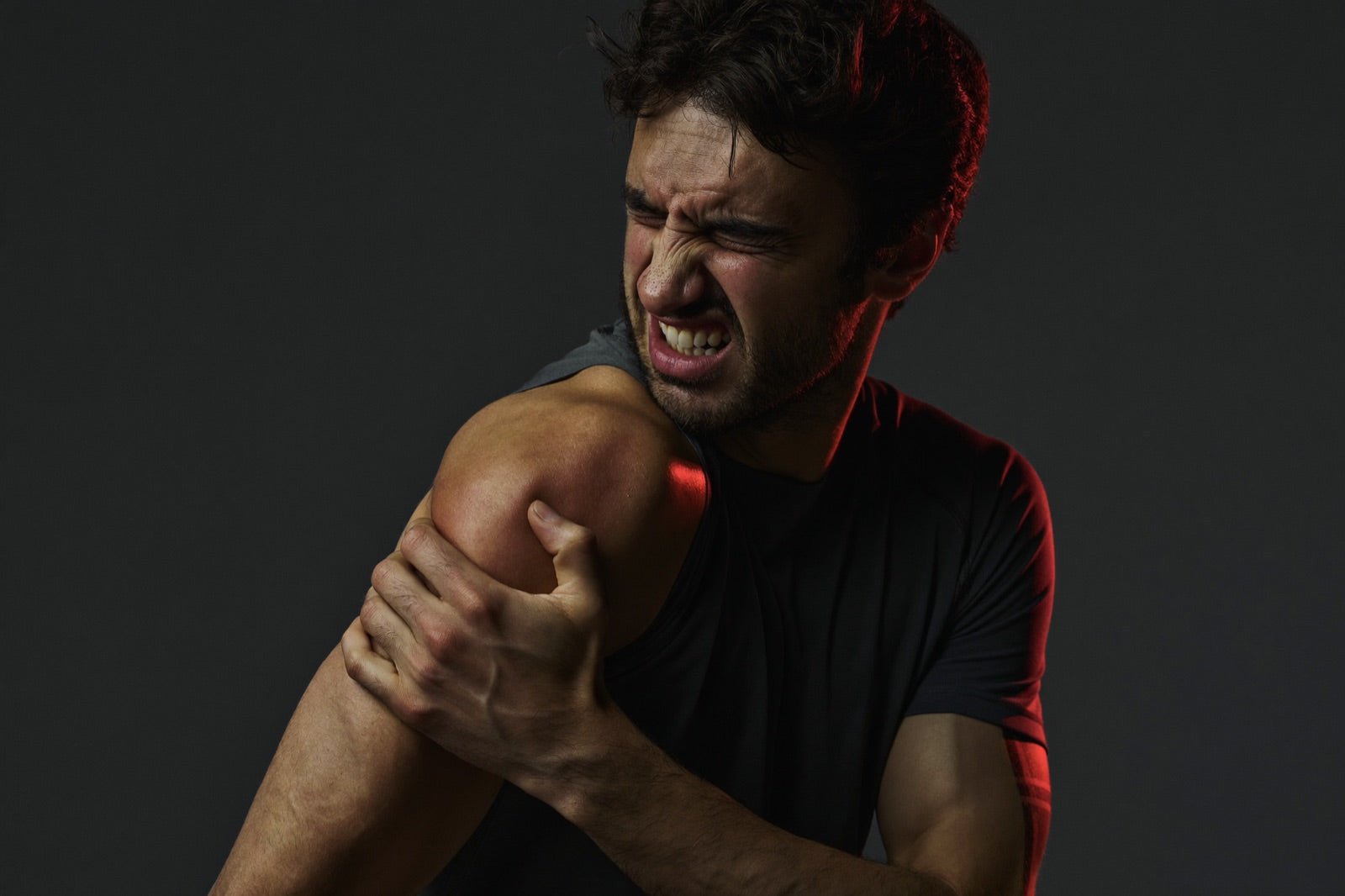 Athlete gripping an aching lead shoulder after a round